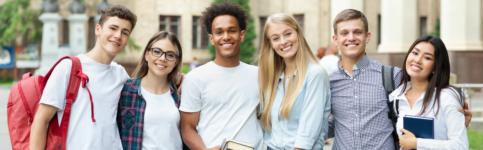 Diverse students in campus, posing in front of university